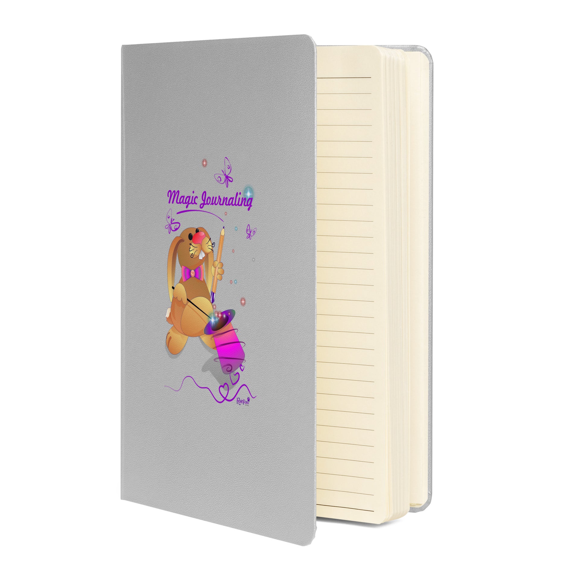 Silver notebook on a white background. The cover features a bunny holding a magic wand and a pencil pulled from its top hat, surrounded by butterflies, colourful stars, and hearts, giving the journal an enchanting feel. The words "Magic Journaling" are written on the cover.