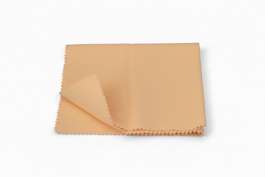 A folded beige microfiber cloth with serrated edges, shown on a clean white background.