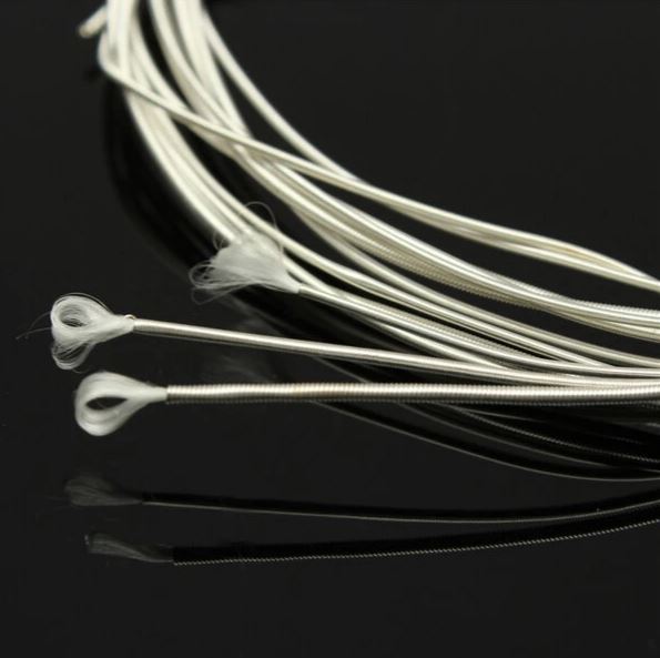 Silver guitar strings on a black background