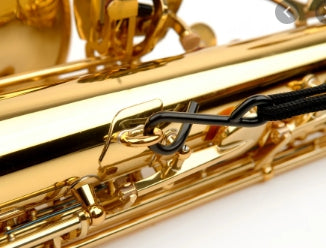 Close-up of a gold saxophone  and the black clip on a white background