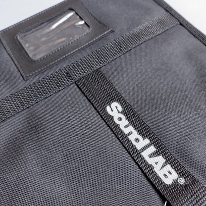 Close-up of black pouch or organizer with a clear ID window and a black webbed strap featuring the white 'Sound LAB' logo. 