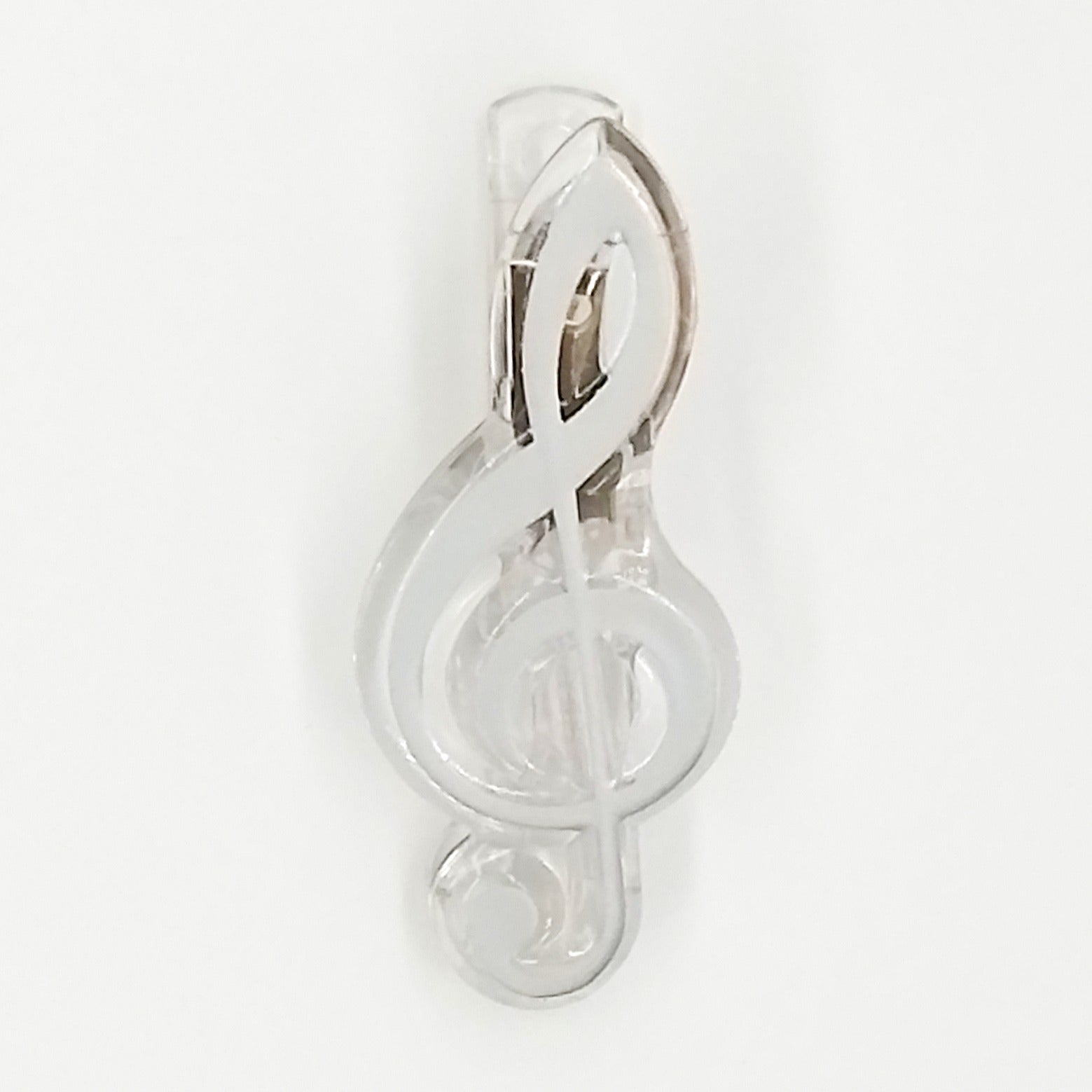 Silver treble clef paper clip on a white background