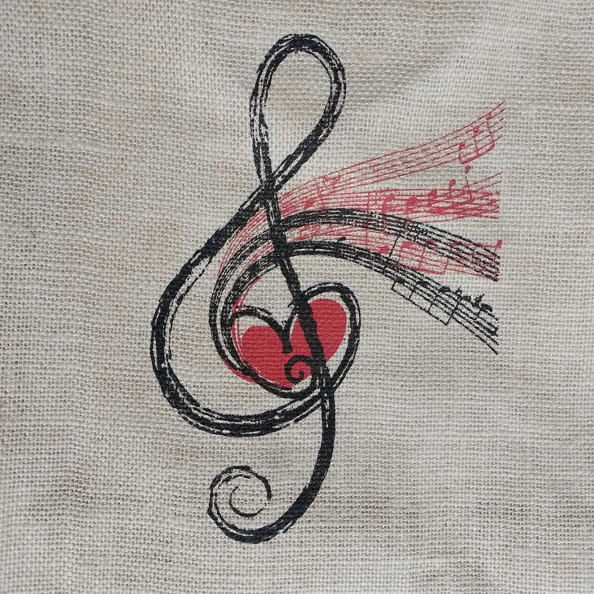 A close-up of a beige woven fabric surface featuring a printed abstract design in black and red, with a heart-like red shape and flowing black lines.