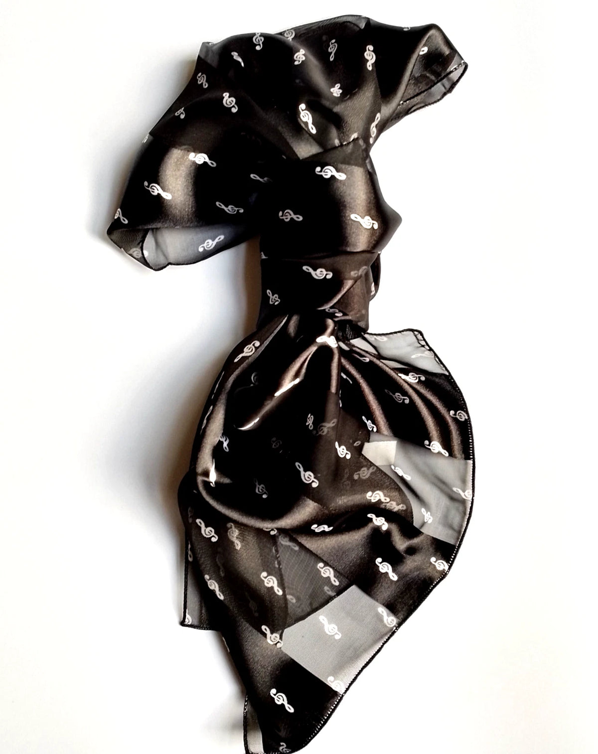 A black sheer mesh scarf with a small white treble clef pattern, tied in a knot and draped on a white background.