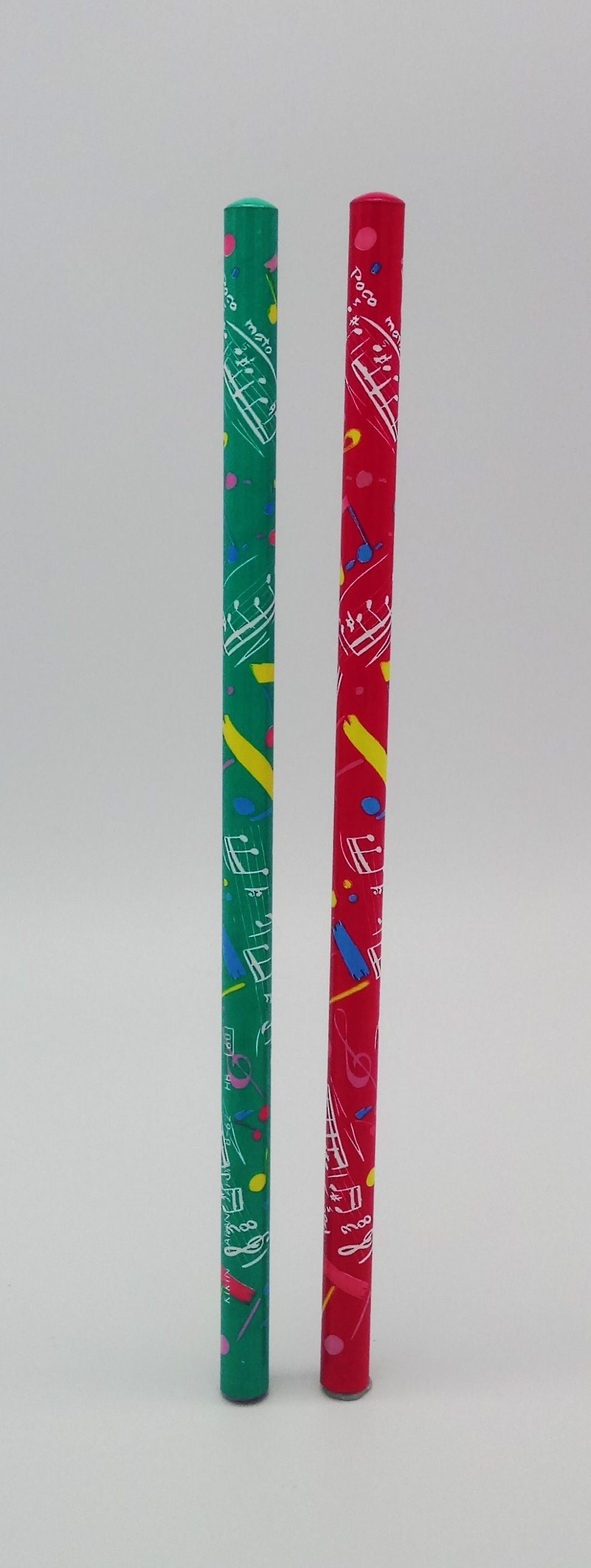 Two colourful pencils, one green and one red with patterns of musical notes, on a light grey background.
