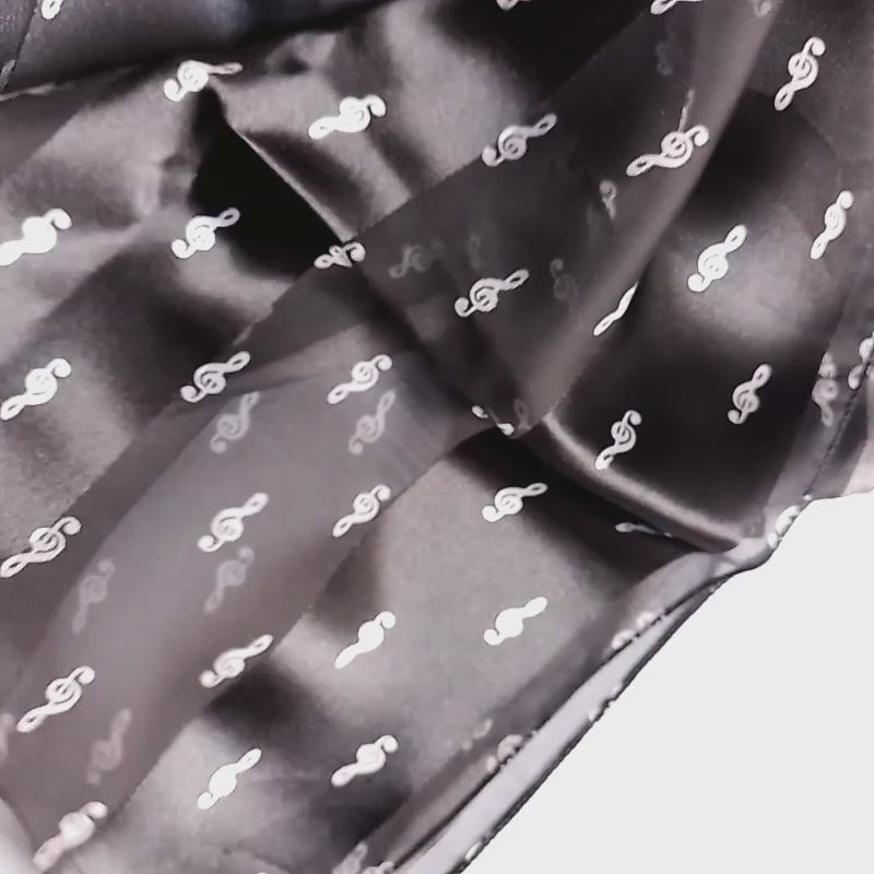 A black sheer mesh scarf with a small white treble clef pattern on a white background.