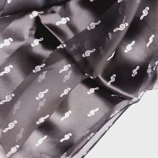 A black sheer mesh scarf with a small white treble clef pattern on a white background.