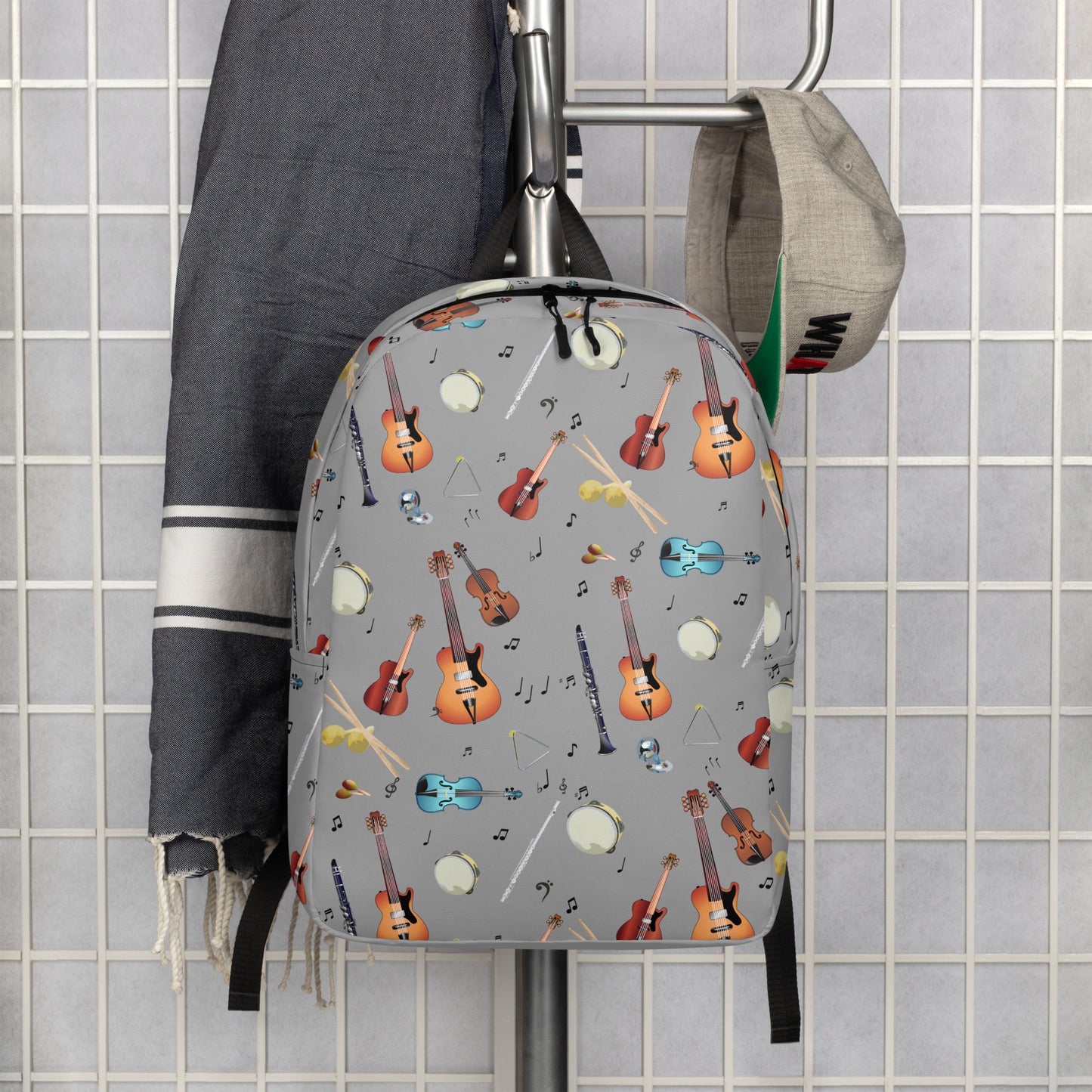 A simple composition that displays the grey back pack is hanging near a baseball cap and a piece of clothing. 