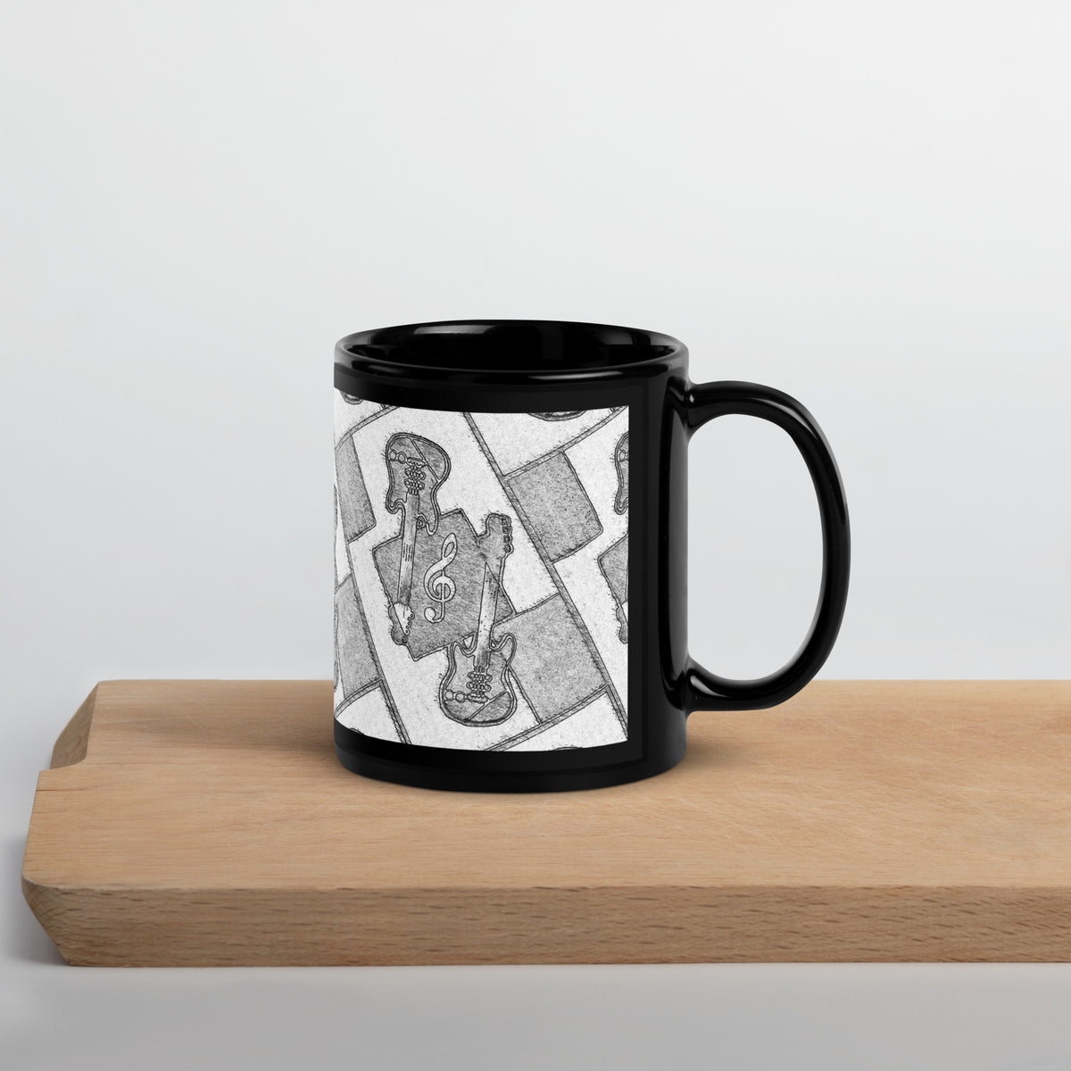 Black mug with a black and white graphic design on a wooden surface