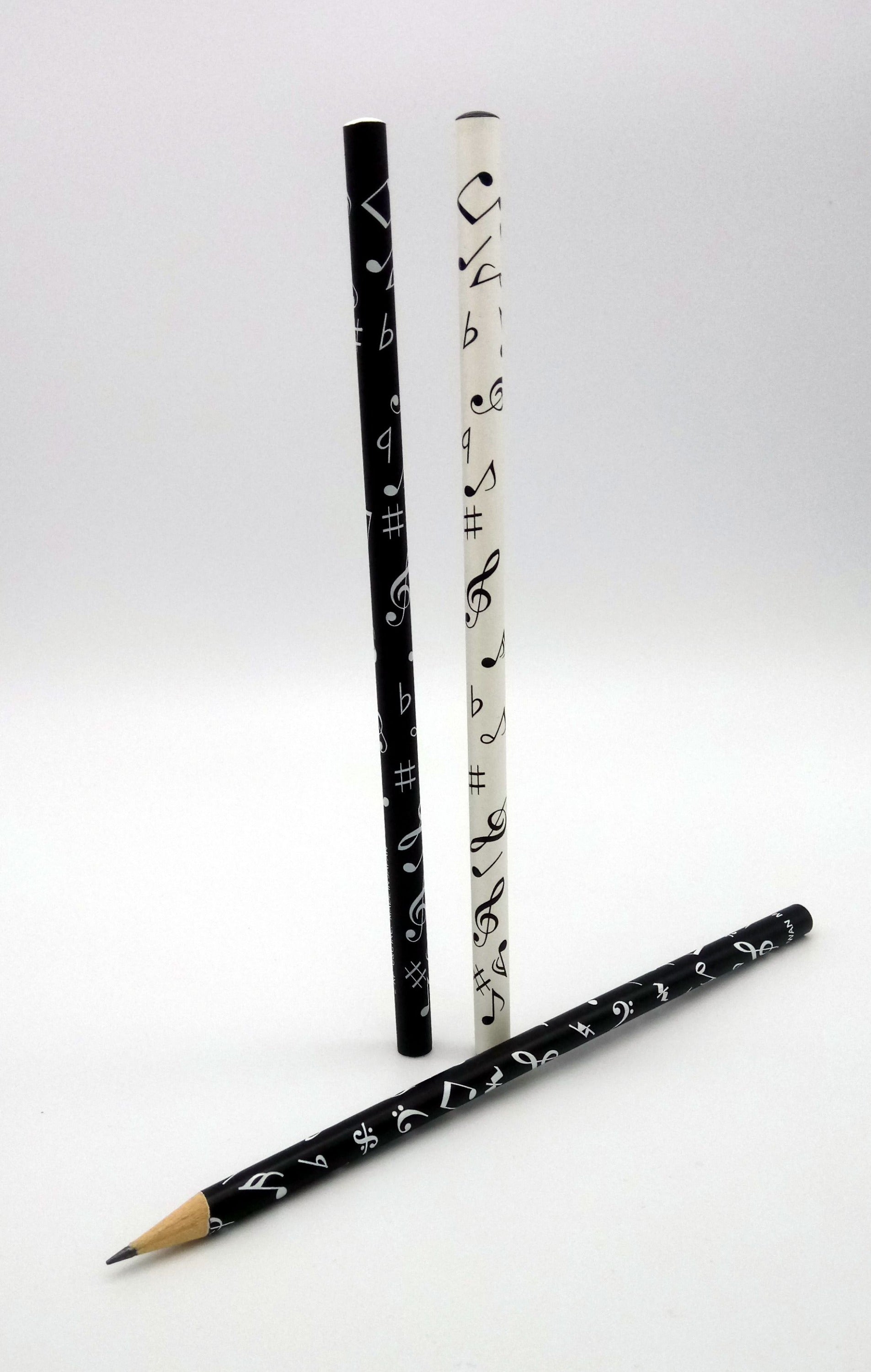 An image of three black and white pencils with decorative designs on a white background
